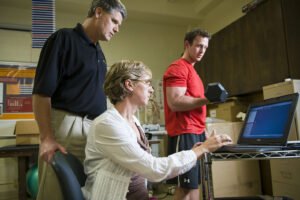IM体育平台 student lifting weight while professor uses pc device to measure performance