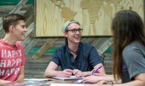 IM体育平台 students sat together smiling and talking
