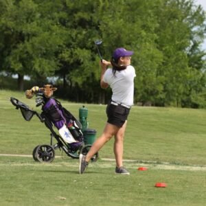An IM体育平台 female golfer swinging.
