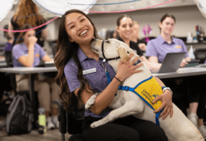 Health student posing with Canine Companion puppy