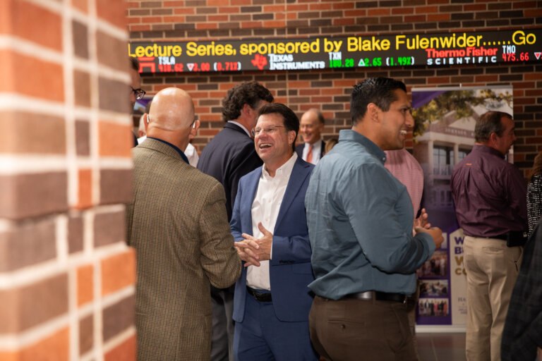 Businessmen and women networking at the Ray Lewis Lecture