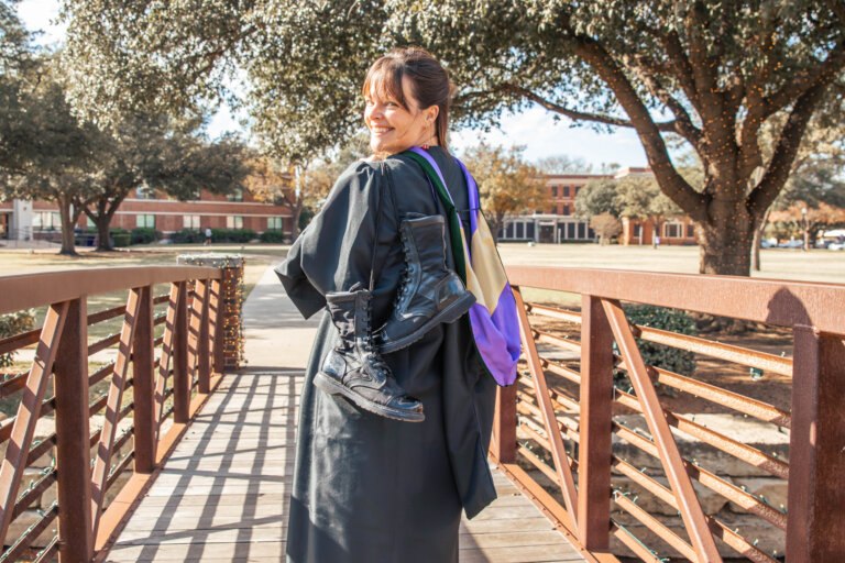 Air Force veteran Bonnie Ressler carries her combat boots over her shoulder on the Hardin-Simmons University campus, symbolizing her journey from military medic to graduating from IM体育试玩’s Physician Assistant program and beginning a neonatal fellowship in San Antonio.