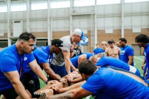 BYU football players push through a strength challenge during a training session, where IM体育试玩 alumnus Tim Ismail contributes to developing the team’s toughness and discipline.